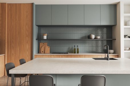 Moderne Küche mit grauen Schränken, Holzdetails und einer zentralen Kochinsel.