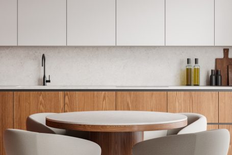 Modern Küche mit Holztisch, hellen Möbeln und minimalistischem Design.