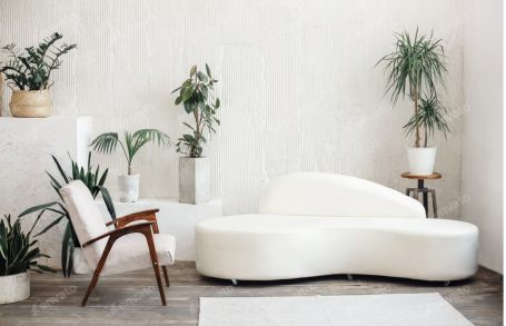 Helle, moderne Sitzecke mit einer weißen Couch und Pflanzen im minimalistischen Design.