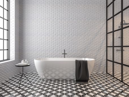 Modernes Badezimmer mit freistehender Badewanne und dekorativem Fliesenboden.