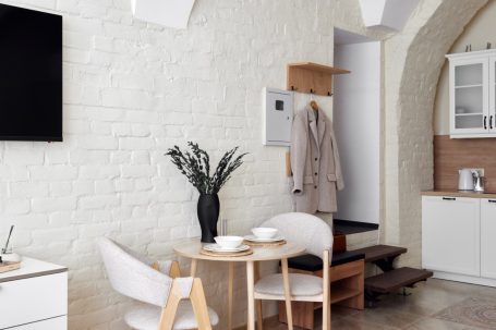 Modern Wohnung mit hellem Interieur, Tisch, Stühlen und einer Küchenecke.