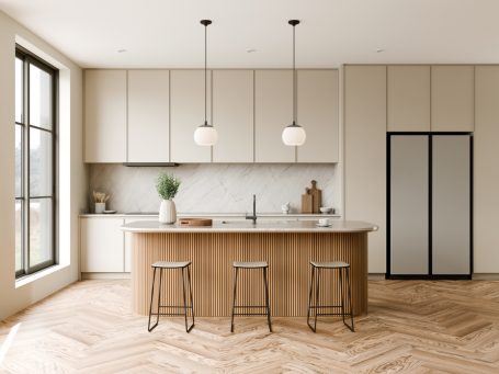 Moderne Küche mit Holzinsel, hängenden Lampen und zwei Barhockern.