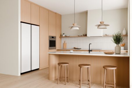 Moderne Küche mit Holzregalen, weißen Geräten und einer zentralen Insel mit Stühlen.